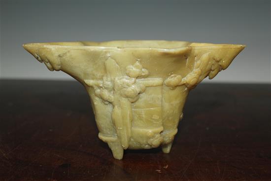 A Chinese pale green soapstone libation cup, 19th century, width 18.5cm, height 10cm, faults